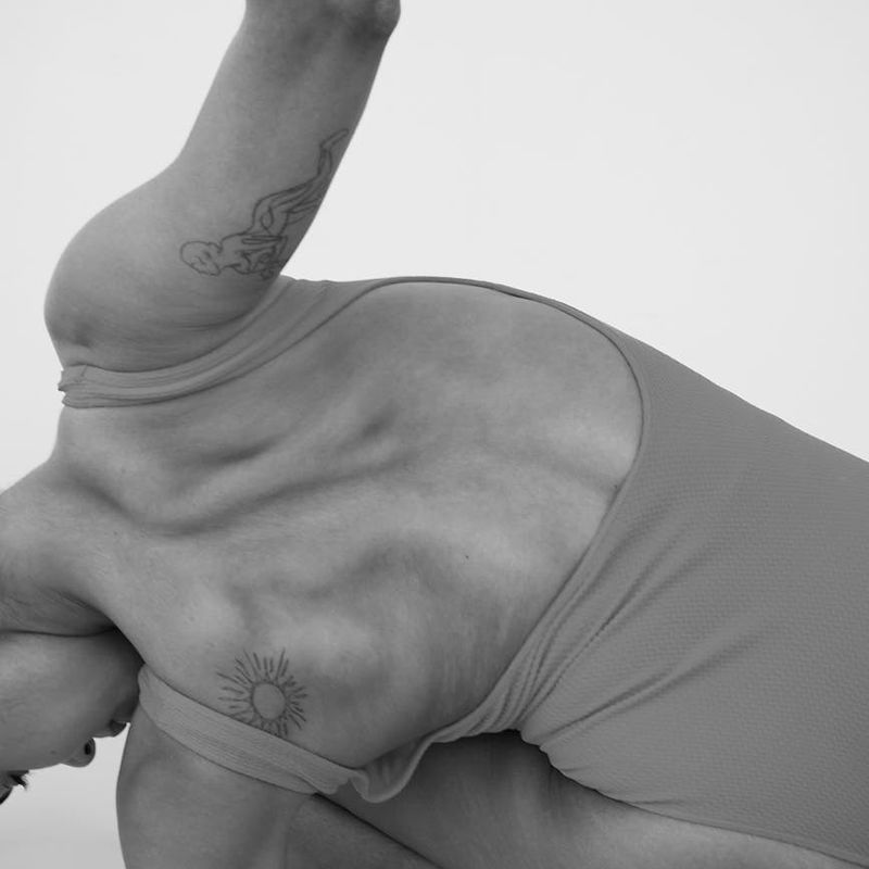 Close-up shot of a person in a deep yoga stretch, showing muscle definition.