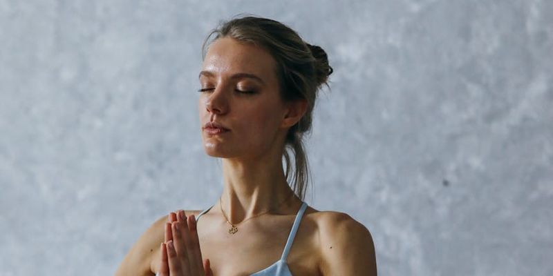 Wide shot of a person holding a difficult balancing yoga pose.